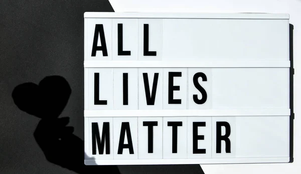 ALL LIVES MATTER text with deep shadows of heart on a black and white background. Protest against the end of racism, anti-racism, equality. Poster on violation of human rights