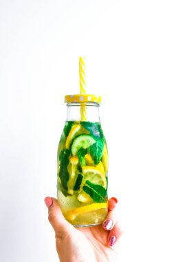 Taze soğuk limon salatalığı, nane şekeri, taze su arıtma içeceği, yaz ferahlatıcı içecek, organik vegan içecek, kadın eli.