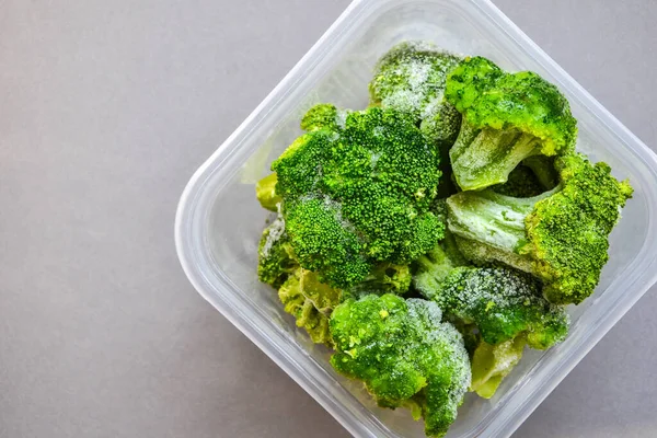 花椰菜在一个塑料容器中长期储存 蔬菜的深度冷冻 灰色背景的冷冻食品蔬菜 文本的复制空间 — 图库照片