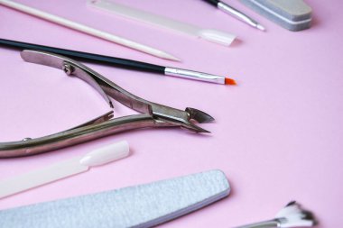 Pembe arka planda manikür ve pedikür aletleri. Manikür salonu afiş tasarım şablonu. Güzellik tedavisi konsepti. Metin için alanı kopyala