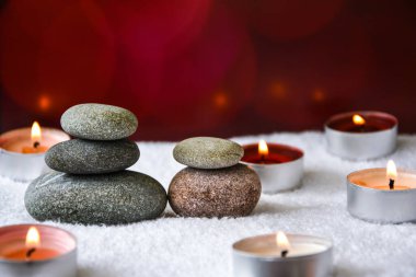 Zen konsepti, spa çakıl taşları ve bulanık arka planda yanan aroma mumları, aromaterapi ve masaj, metin için kopyalama alanı