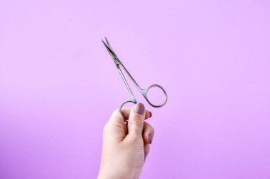 El ele tutuşmalar, pembe arka planda manikür ve pedikür aletleri. Manikür salonu afiş tasarım şablonu. Güzellik tedavisi konsepti. Metin için alanı kopyala