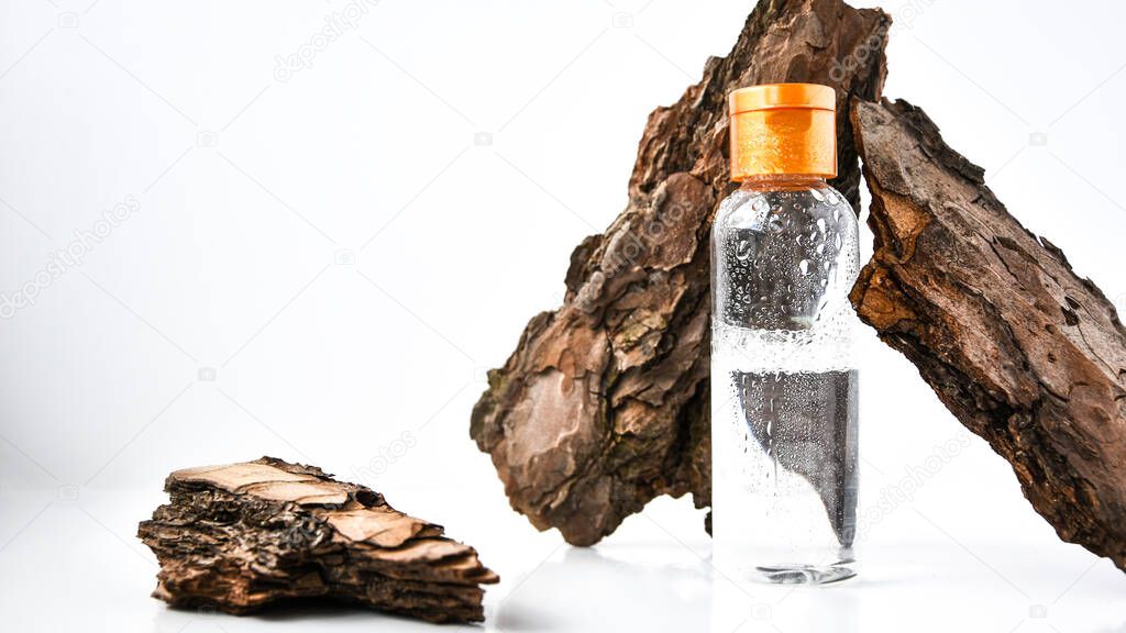 Perfume in tree bark with drops of water. texture. concept of freshness and naturalness. the aroma of wood and morning dew. autumn melancholy. copy space, oil is mixed with water in a spray bottle.