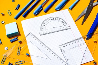 Okul malzemeleri sarı arka plan, fotokopi alanı, makas, kalem, ataç, kural koyucu, çıkartma. Okula dön, evde çalış.