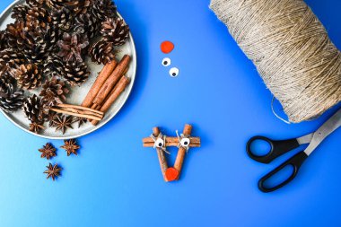 Noel süsü yapmanın en güzel manzarası. Tarçın çubuklarından geyik. Çocuk sanat projesi, çocuklar için bir zanaat. Diy konsepti. Adım adım 4. Doğal Noel süslemeleri