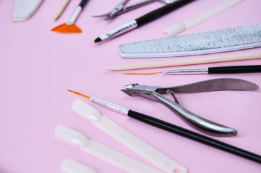 Pembe arka planda manikür ve pedikür aletleri. Manikür salonu afiş tasarım şablonu. Güzellik tedavisi konsepti. Metin için alanı kopyala