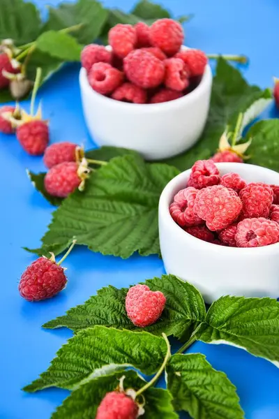 Fresh Ripe Raspberries Green Leaves Blue Background Summertime Harvest Berries — Stock Photo, Image