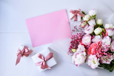 Zarif buket ve hediye kutularıyla kart maketi. Çiçek arkaplanı. Top view Flat Lay Holiday kartı 8 Mart, Sevgililer Günün kutlu olsun, Anneler Günü konsepti. Uzayı metin için kopyala. Tatil tebrik kartı.