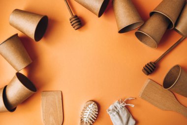 Çevre dostu tek kullanımlık kağıt bardaklar, ahşap mutfak aletleri, sarı arka planda saç fırçası pamuk torbası. Uzayı kopyala Eko fast food. Plastiksiz. Sıfır kayıp. Çevre dostu materyal