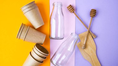 Ev atıkları geri dönüşüm için sınıflandırılıyor. Çevre koruma kavramı. Sıfır atık, plastiksiz. Kağıt bardaklar. Renkli arka planda ahşap mutfak araçları