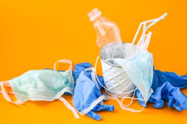 COVID-19 Tıbbi Atık. Eldivenler, maskeler, boş plastik dezenfektan şişeleri. Kişisel koruyucu ekipman PPE kullanılmış. Salgından sonra plastik kirliliği. Coronavirus plastik çöplüğü