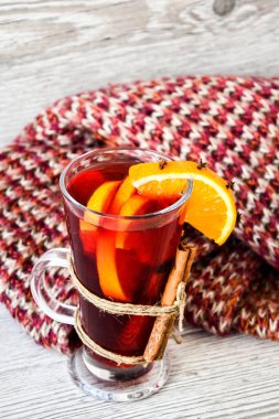 Sıcak şarap, ahşap arka planda baharatlar olan sıcak noel içeceği. Portakal dilimi, tarçın çubukları, kazak. Noel sabahı. Tatil atmosferi, taşra tarzı. Tebrik kartları oluşturma fikri