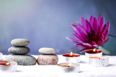 Zen konsepti, spa çakıl taşları ve bulanık arka planda yanan aroma mumları, aromaterapi ve masaj, metin için kopyalama alanı