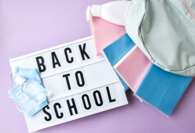 Işık kutusu, okul koruyucu yüz maskesi ve dezenfektanına geri döndü. Yeni normal. Sırt çantasından düşen kitaplar. Sosyal uzaklık. 2020 Karantina Eğitimi