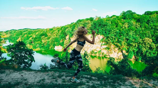 Woman running in mountains, young fitness woman trail runner running on grassland. Sport outdoors.