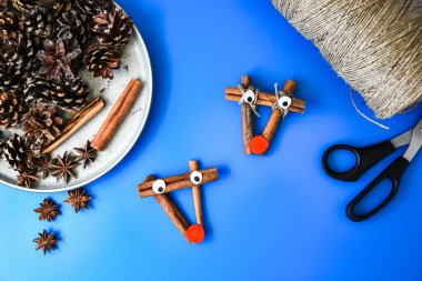 Noel süsü yapmanın en güzel manzarası. Tarçın çubuklarından geyik. Çocuk sanat projesi, çocuklar için bir zanaat. Diy konsepti. Adım adım 4. Doğal Noel süslemeleri