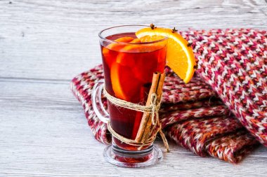 Sıcak şarap, ahşap arka planda baharatlar olan sıcak noel içeceği. Portakal dilimi, tarçın çubukları, kazak. Noel sabahı. Tatil atmosferi, taşra tarzı. Tebrik kartları oluşturma fikri