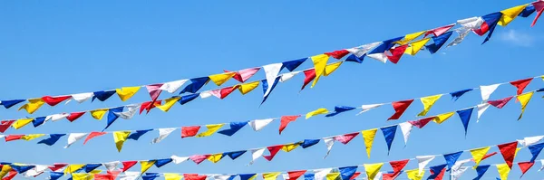 multi colored party rainbow flags on blue sky for celebration. Flags Colors Blue Sky. Color party flags festival