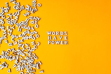 Alıntı kelimelerin parlak sarı arkaplandaki ahşap harflerden yapılmış bir gücü vardır. Motive edici Kelimeler Alıntılar Kavramı