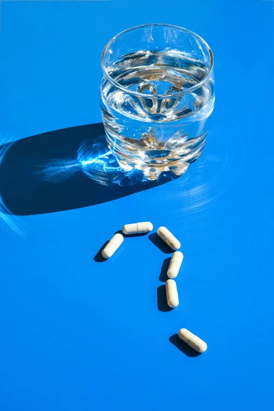 Glass Water Pills Shape Question Mark Blue Background Hard Light — Stock Photo, Image
