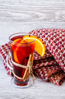 Sıcak şarap, ahşap arka planda baharatlar olan sıcak noel içeceği. Portakal dilimi, tarçın çubukları, kazak. Noel sabahı. Tatil atmosferi, taşra tarzı. Tebrik kartları oluşturma fikri