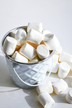 Beyaz mini marşmelov arka plan yakın çekim dokusu. Yemek arkaplanı. Uzayı kopyala Beyaz arkaplanda beyaz metal kova