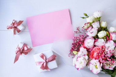 Zarif buket ve hediye kutularıyla kart maketi. Çiçek arkaplanı. Top view Flat Lay Holiday kartı 8 Mart, Sevgililer Günün kutlu olsun, Anneler Günü konsepti. Uzayı metin için kopyala. Tatil tebrik kartı.