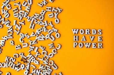 Alıntı kelimelerin parlak sarı arkaplandaki ahşap harflerden yapılmış bir gücü vardır. Motive edici Kelimeler Alıntılar Kavramı