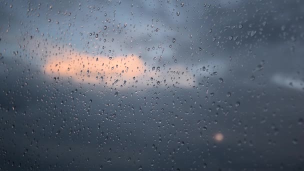 Nuvens inchadas passando no céu azul com a luz do sol brilhando com gotas de chuva em uma janela de vidro em foco. Desfasamento temporal — Vídeo de Stock