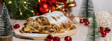 Noel ışıkları ve dekorasyonuyla çalınmış Noel. Geleneksel meyveli somun şekerli, şenlikli tatlı. Tatil pişirme konsepti. 