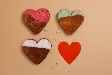 Yaratıcı idealler sevgililer günü düz açıda tatil kutlamaları yatıyordu. Kalp, bej arka planda farklı aromalı kruvasanlar şekillendirdi. Puf böreği yeni moda tatlı pastanesi