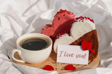 Tebrik kartında sabah kahvaltısı, ahşap tepside hediye paketinde Sevgililer Günü kutlaması, kalp şeklinde kruvasanlar. Puf böreği yeni moda tatlı pastanesi