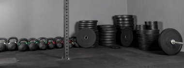 Diskolar de levantamiento de varios pesos con una barra para ejercicios al lado y Kettlebells de varios pesos