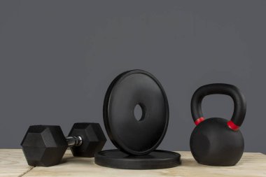 Dumbbell, discos y Kettlebell de crossfit sober caja de madera y fondo gris
