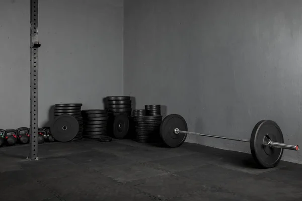 Diskolar de levantamiento de varios pesos con una barra para ejercicios al lado
