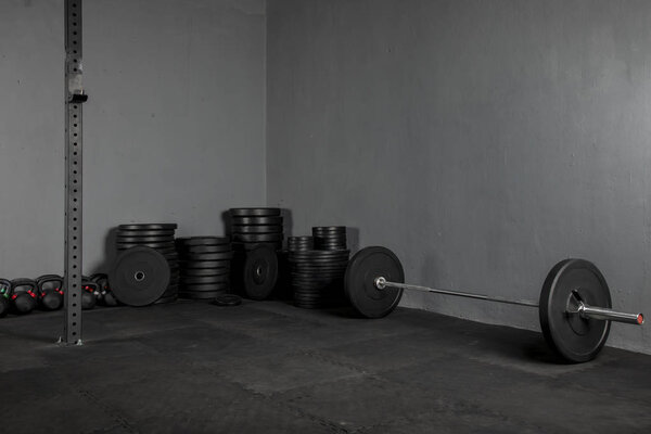 Discos de levantamiento de varios pesos con una barra para ejercicios al lado