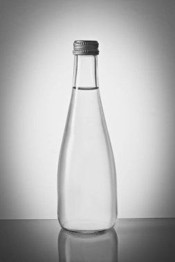 Arkaplanı eğimli cam su şişesi.