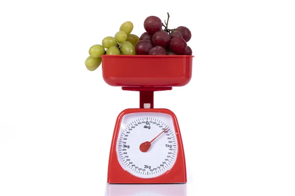Üzerinde yeşil ve mor üzümler olan tartı