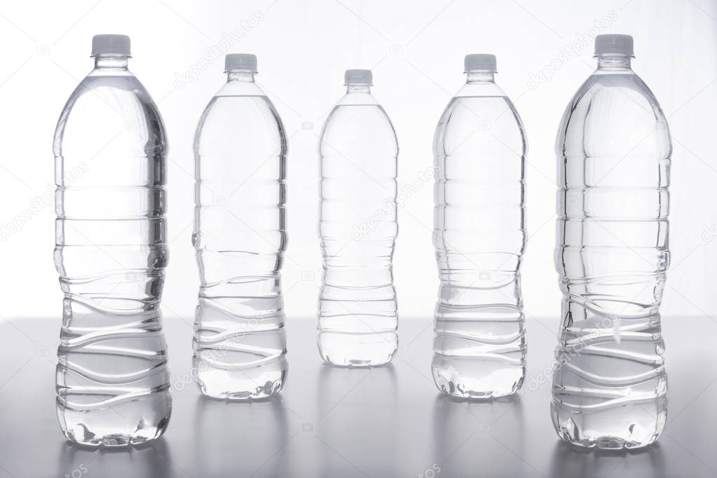 Botella de agua transparentes sobre superficie lisa con fondo blanco