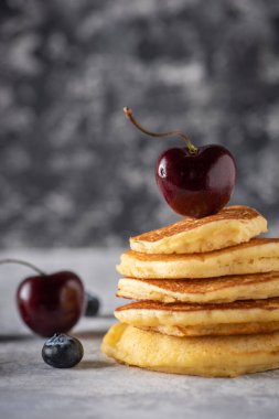 Kiraz ve yaban mersinli sıcak kekler eski, gri ahşap bir masada. Metin için boşluk