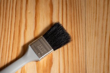 Boya fırçası ahşap bir yüzeye ve kenara metin için yere yerleştirildi