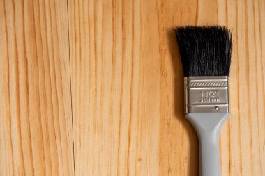 Boya fırçası ahşap bir yüzeye ve kenara metin için yere yerleştirildi