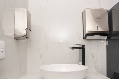 Biri sabun için diğeri de hijyenik peçeteler için olmak üzere iki şeker kutusuyla mermer bir zeminde lavabo açılır.