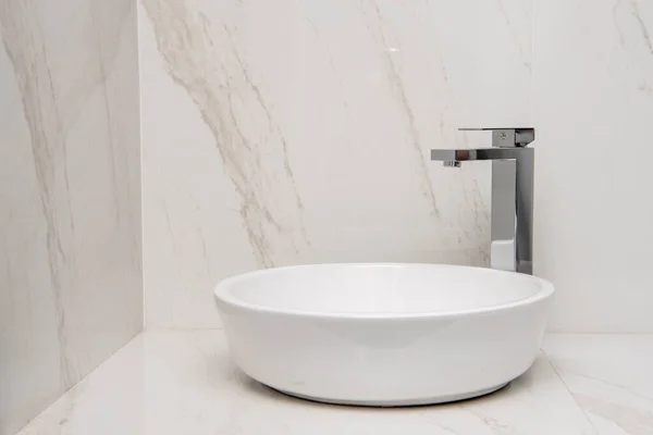 Sink with mixer on a marble base and walls