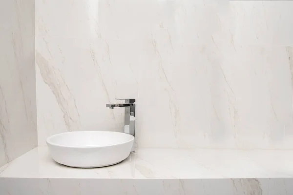 Sink with mixer in a bathroom with marble finishes