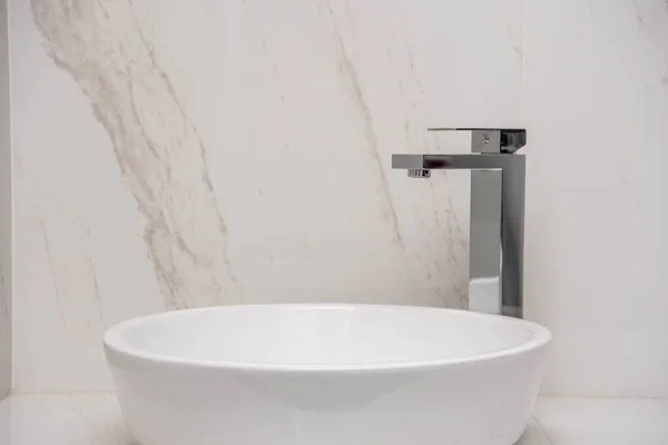 Sink with mixer on a marble base and walls