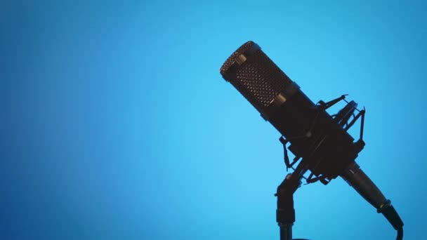 Stolní Mikrofon Kabelem Podstavci Zatáčky Změnami Osvětlení Modrým Pozadím Sklonu — Stock video