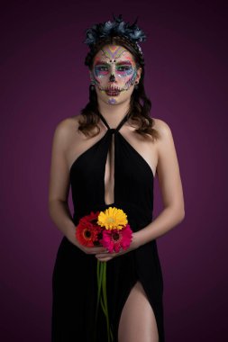 Siyah elbiseli ve renkli geçmişli Catrina.