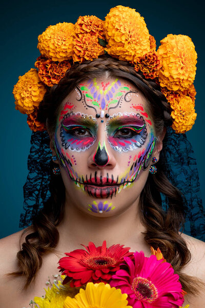 Catrina with marigold flowers on her head and in her hands
