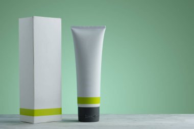 Kutusu ve yeşil gradyan arka planı olan krema kutusu